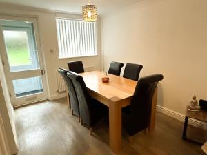 a dining room table with black chairs around it at 3 Double Bedrooms, Lancashire Townhouse, Free Parking in Upholland +11 photos