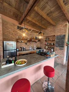 a kitchen with a counter and two red stools at Casa Camprestre Hika in Machetá