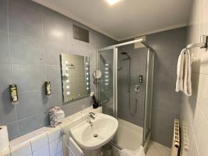 a bathroom with a sink and a shower at Hotel Sonnengarten Apartments in Überlingen