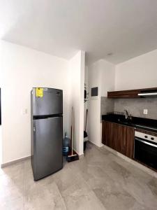 eine Küche mit einem Kühlschrank aus Edelstahl in einem Zimmer in der Unterkunft Acogedor Fast WIFI 5ta Avenida in Playa del Carmen