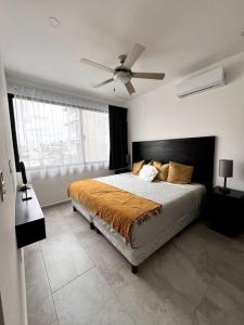 ein Schlafzimmer mit Bett und Deckenventilator in der Unterkunft Acogedor Fast WIFI 5ta Avenida in Playa del Carmen