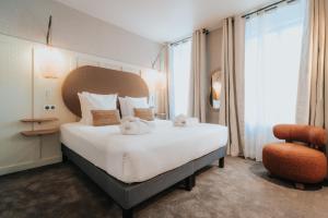 Ένα ή περισσότερα κρεβάτια σε δωμάτιο στο Hôtel Henry II Beaune Centre