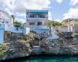 a house on a cliff next to the water at Blue Lagun Apartment B in Willemstad +2 photos