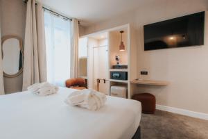 Ένα ή περισσότερα κρεβάτια σε δωμάτιο στο Hôtel Henry II Beaune Centre
