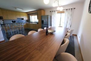 ein Esszimmer mit einem Holztisch und Stühlen in der Unterkunft high standard rental in a quality residence with pool, tennis and view of the ocean in antas esposende 12 people in Estrada