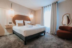Ένα ή περισσότερα κρεβάτια σε δωμάτιο στο Hôtel Henry II Beaune Centre