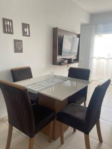 a dining room table with two chairs and a television at Apartamento Madero in Umuarama +15 photos