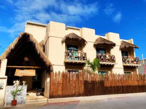 a building with a fence in front of it at Hotel Pelecanus Suites Holbox in Holbox Island