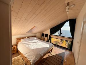 MăguriにあるCasa de Jos - Pe Dealul Mieilor - Cabană cu Jacuzzi și Saună în Măguriのベッドと大きな窓のある寝室 +63枚の写真