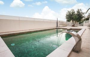 ein Schwimmbad mit einer Brücke über das Wasser in der Unterkunft Gorgeous Home In Marina Di Ragusa in Marina di Ragusa