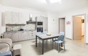 eine Küche und ein Esszimmer mit Tisch und Stühlen in der Unterkunft Gorgeous Home In Marina Di Ragusa in Marina di Ragusa