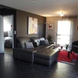 sala de estar con sofá de cuero en una habitación en La Maison d'Anne, en Ribeauvillé