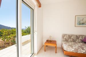 a living room with a couch and a sliding glass door at Dream Villas in Lefkos Karpathou