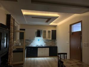 a room with a kitchen with a sink and a table at Urban Zen Oasis - Independent floor in City Centre in Gwalior +10 photos
