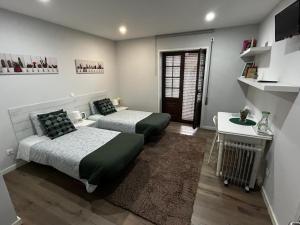 アヴェイロにあるCasa Pirosa2のベッド2台とテーブルと机のある寝室