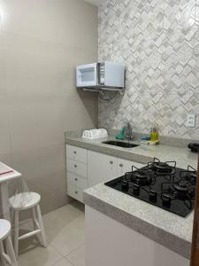 a kitchen with a stove and a counter top at Novíssimo apt 1 quarto Centro frente à Prefeitura in Nova Friburgo