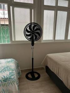a bedroom with a fan next to a bed at Novíssimo apt 1 quarto Centro frente à Prefeitura in Nova Friburgo