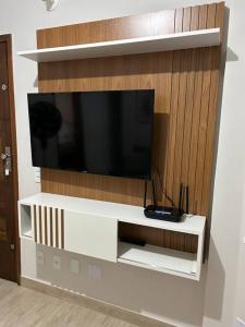 a white entertainment center with a flat screen tv on a wall at Novíssimo apt 1 quarto Centro frente à Prefeitura in Nova Friburgo