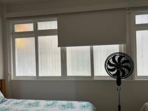a bedroom with a bed and a window with a roller blind at Novíssimo apt 1 quarto Centro frente à Prefeitura in Nova Friburgo