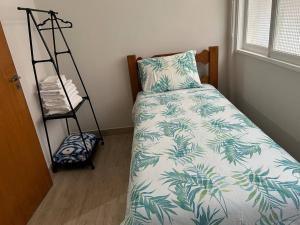 a bedroom with a bed with a pillow and a shelf at Novíssimo apt 1 quarto Centro frente à Prefeitura in Nova Friburgo