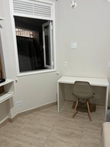a desk and a chair in a room with a window at Novíssimo apt 1 quarto Centro frente à Prefeitura in Nova Friburgo