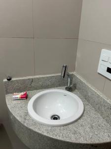 a bathroom counter with a white sink and toothpaste at Novíssimo apt 1 quarto Centro frente à Prefeitura in Nova Friburgo