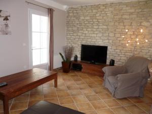 sala de estar con pared de piedra y TV en house in the countryside in the luberon with beautiful view and private swimming-pool close to bonnieux in Provence - 8 personnes, en Bonnieux