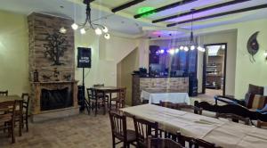 a restaurant with tables and chairs and a fireplace at Xenonas Arxontariki in Mikrón Dhérion