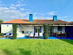 a house with a patio with chairs and a table at Comporta - Wood & Blue in Comporta