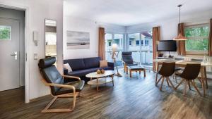 a living room with a blue couch and a table at A plus Ferienpark Usedom in Ostseebad Koserow