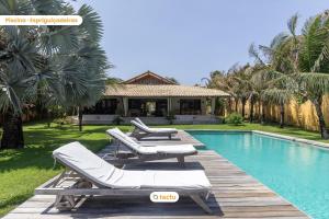 a pool with two lounge chairs and a house at Paraíso de Luxo à Beira-mar no Fortim in Maceio