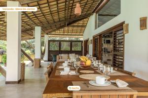 a dining room with a long table in a house at Paraíso de Luxo à Beira-mar no Fortim in Maceio