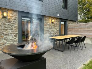 a fire pit in a patio with a table and chairs at Hyronimus House in Amblève