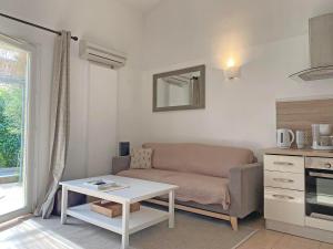 a living room with a couch and a table at pleasant gîte, with collective heated swimming pool, in the heart of the alpilles in mouriès, 4/6 people. in Mouriès