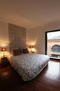 ein Schlafzimmer mit einem großen Bett und einem großen Fenster in der Unterkunft Le Duplex in Toulouse
