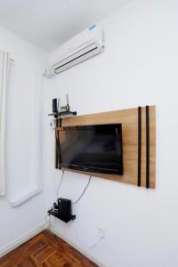 a flat screen tv hanging on a wall at Espaço inteiro no Centro Histórico, bem localizado in Porto Alegre
