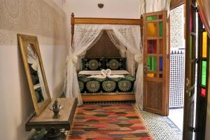 a bedroom with a bed and a mirror and a door at Riad Rayhana-Exclusive Riad Experience in Fes Medina in Fès +41 photos