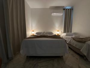 two beds in a room with two lamps on them at Casa Mar Arraial d'Ajuda in Arraial d'Ajuda +13 photos