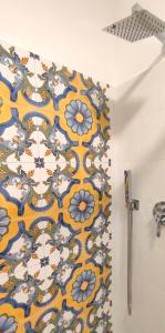 a bathroom with a yellow and blue patterned shower curtain at Ancient Rome Colosseum modern and bright apartment in Rome +44 photos