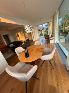 a living room with a wooden table and chairs at Weisse Villa am Millstätter See in Obermillstatt