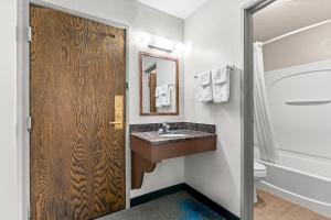 a bathroom with a sink and a mirror at Days Inn by Wyndham Sioux Falls in Sioux Falls +66 photos