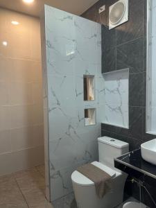 a bathroom with a white toilet and a sink at J House Has Love in Sukhothai