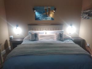 a bedroom with a large bed with two lights at Seas the Breeze in Boknes
