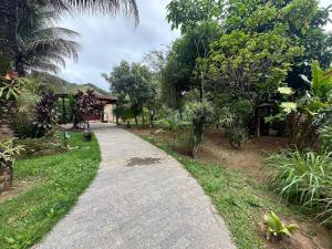 a path in a garden with trees and a building at Refúgio Maravilhoso na barra do Sana | SAAP376 in Sana