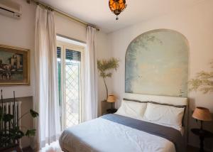 ein Schlafzimmer mit einem Bett und einem großen Fenster in der Unterkunft Villa Mara Appia antica in Rom