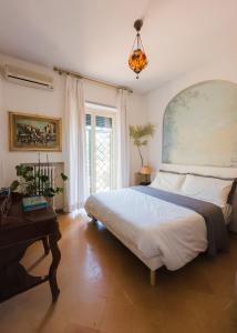 ein Schlafzimmer mit einem großen Bett und einem Tisch in der Unterkunft Villa Mara Appia antica in Rom