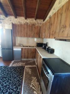 a kitchen with wooden cabinets and a stove and a refrigerator at Drymaia Chalet in Amfikleia +9 photos