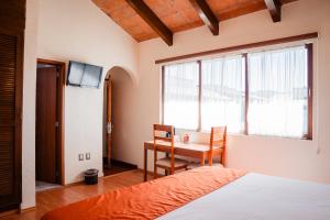 Un dormitorio con una cama y una mesa y una ventana. en Hotel Del Angel, Apizaco, en Apizaco