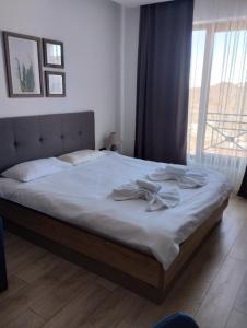 a bedroom with a bed with white sheets and a window at Milmari apartman SAN-28 in Kopaonik +20 photos