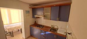 a small kitchen with blue cabinets and a sink at Apartament Alina Et 1 in Mangalia